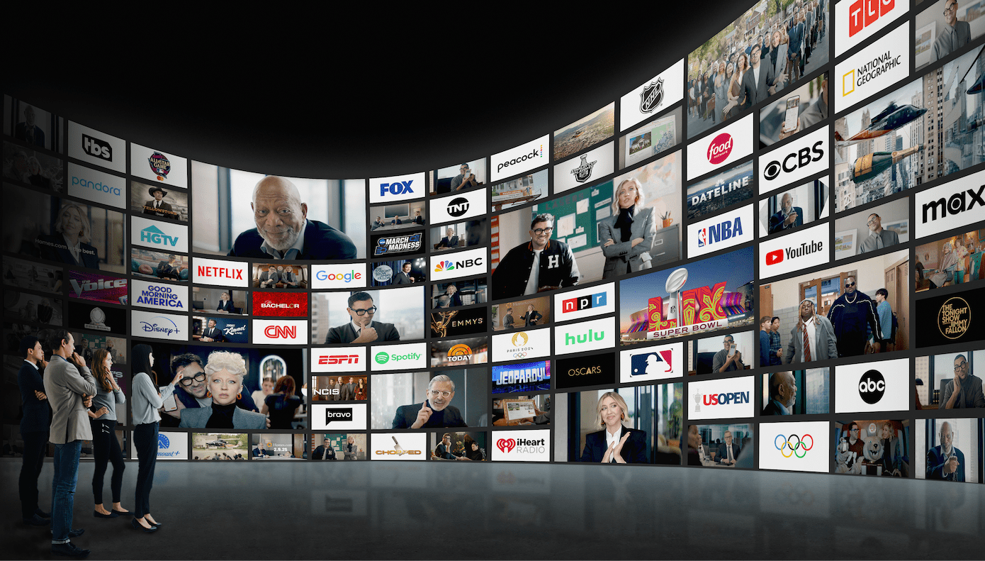 Wall of screens showing FOX, CBS, NBC, ABC, CNN, ESPN, NFL, NBA, Hulu, Netflix, Google, YouTube, iHeart Radio, Peacock, Paramount+, Disney+, Max, and dozens more major media brands